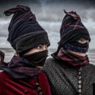 Foto af to kvinder i Fanødragt med strude (maske) – Ormegravere på Fanø – fotografi af Ole Joern billedet hænger på Fanø Bryghus